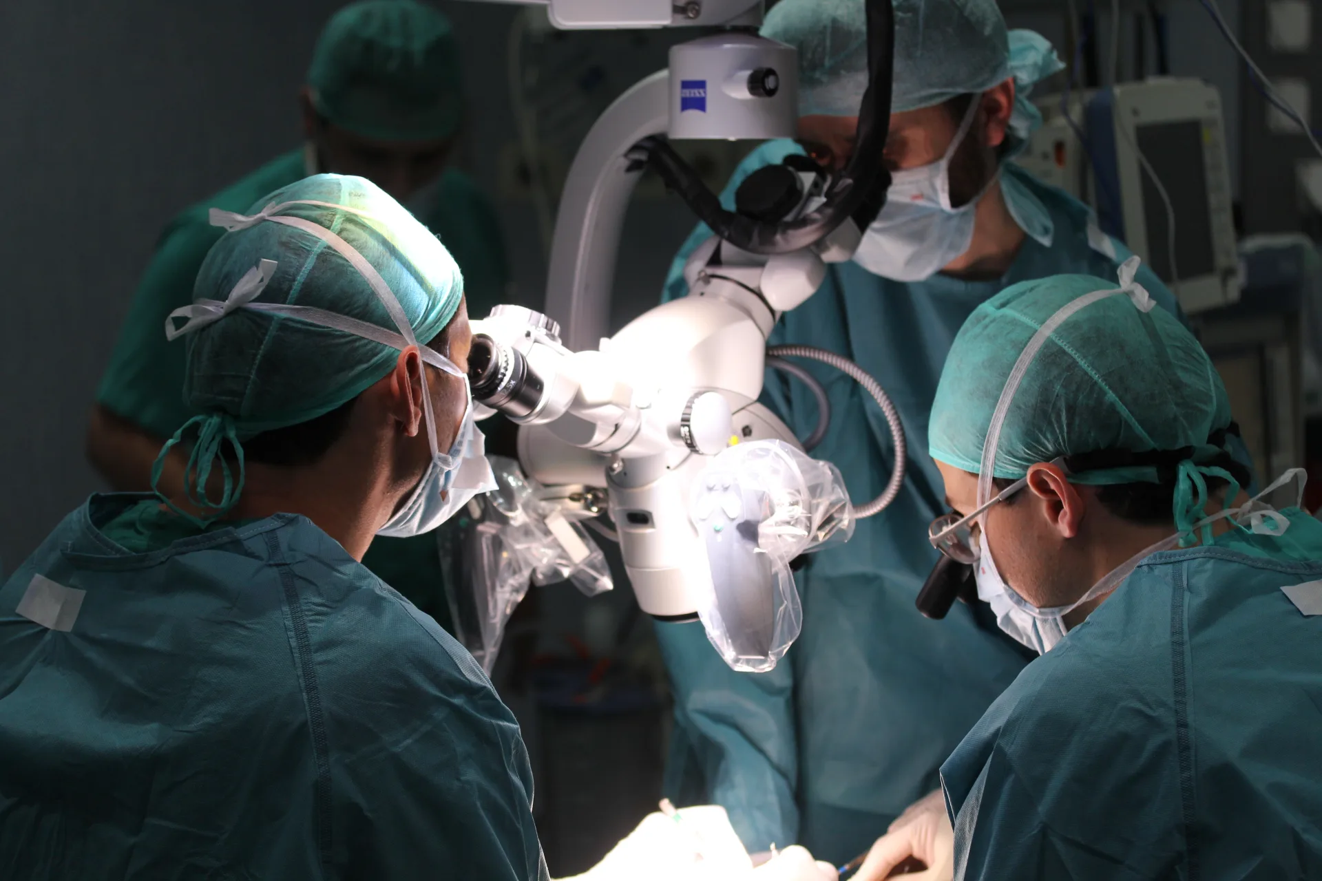 Dr. Roger de Oña operando con microscopio Zeiss — microcirugía reconstructiva